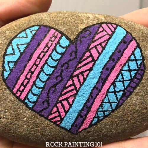 Create striped heart rocks with fun designs in them. Create rock painting project for beginners.