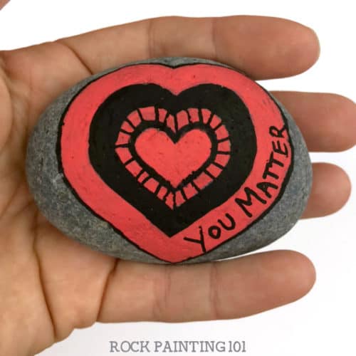 Are you participating in International Drop A Rock Day? Check out all the fun details about this fun day that takes rock hunting to a new level by spreading love and kindness around the world. #internationaldroparockday #droparock #kindnessrocks #youmatter #redheart #howtopaintrocks #heartrocks #rockpainting101