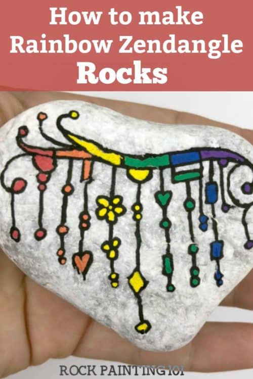 We are loving this rainbow zendangle painted rock! Let the colors of the rainbow dangle to create this beautiful and fun rock painting idea. #zendangle #rainbow #dangles #howtopaintrocks #howtozendangle #rainbowrocks #rockpainting #stonepainting #rockpainting101