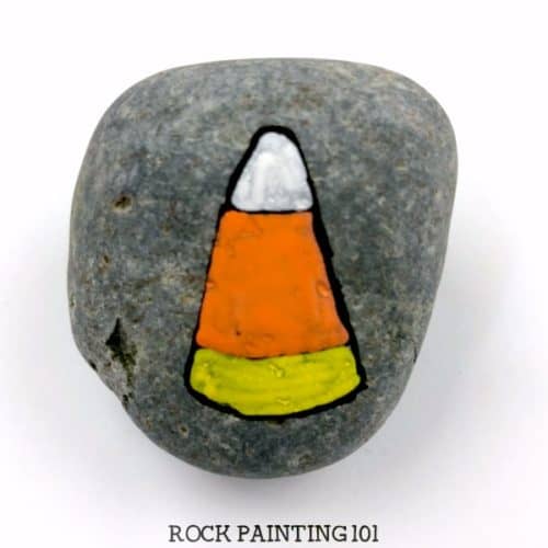 Create adorable candy corn painted rocks with this simple and fun tutorial. This Halloween rock painting idea is perfect for trick or treaters or to decorate this season! #halloweenrockpainting #candycorn #candy #paintedrocks #halloweencandy #trickortreat #noncandyhalloween #rockpainting101