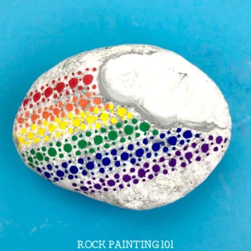 This fun dotted rainbow rock is perfect for beginners and makes a fun kindness rock painting idea! #rainbow #rockpainting #kindnessrocks #bearainbow #howtopaintrocks #rockpaintingideas #stonepainting #paintedrocks #rockart #rockpainting101
