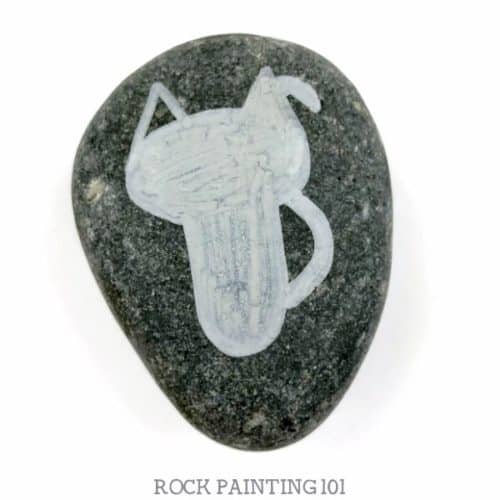 Learn how to paint a cat on rocks with this simple video tutorial. Grab your paint pens or your favorite paint brush and let's create this easy stone painting idea. #catrocks #howtopaintacat #rockpaintingidea #paintedrocks #stonepaintingideas #rockpainting101