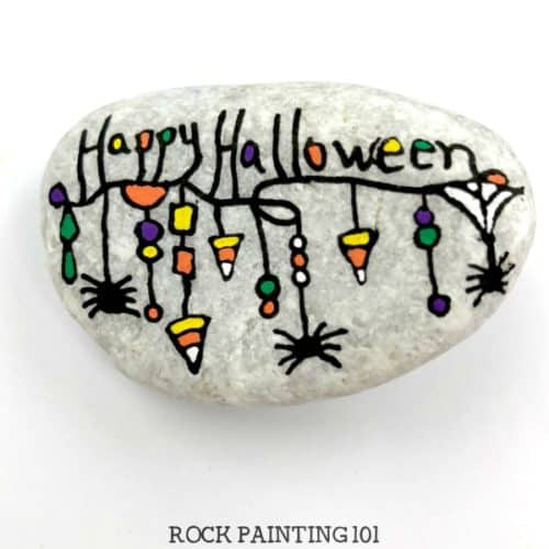 Create a fun Halloween zendangle painted rock with these simple tips and quick tutorial. This rock painting idea is perfect for hiding this Halloween. #halloween #zendangle #rockpaintingideas #fall #halloweenstones #howtozendangle #rockpainting101