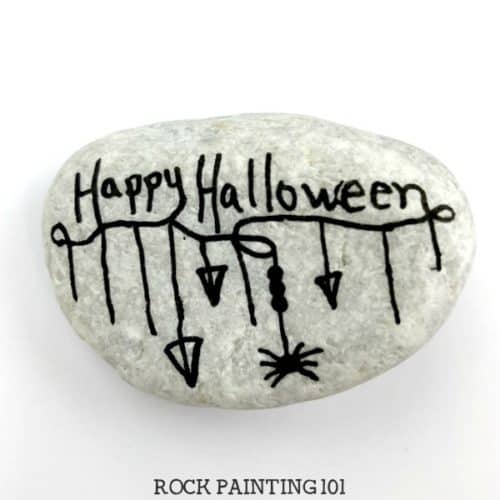 Create a fun Halloween zendangle painted rock with these simple tips and quick tutorial. This rock painting idea is perfect for hiding this Halloween. #halloween #zendangle #rockpaintingideas #fall #halloweenstones #howtozendangle #rockpainting101