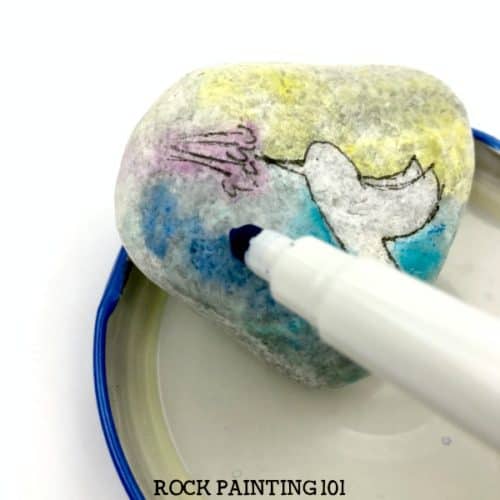 Paint a beautiful hummingbird using a simple technique. Create the look of watercolors without the difficulty and you'll paint a beautiful rock. #watercolor #hummingbird #howtopaintrocks #stonepainting #paintedrocks #rockart #howtopaint #rockpainting101