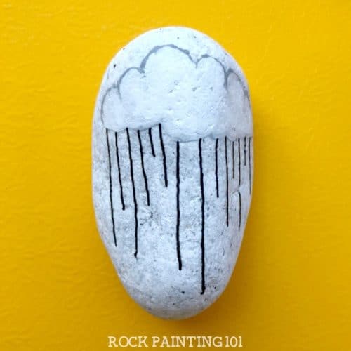 This fun raincloud zendangle painted rock is a great rock painting idea for beginners or for those looking to improve their skill. #zendangle #raincloud #kindnessrocks #rockpainting #paintedrocks #rockart #howtozendangle #dangles #rockpainting101