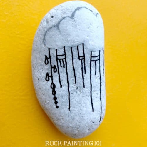 This fun raincloud zendangle painted rock is a great rock painting idea for beginners or for those looking to improve their skill. #zendangle #raincloud #kindnessrocks #rockpainting #paintedrocks #rockart #howtozendangle #dangles #rockpainting101