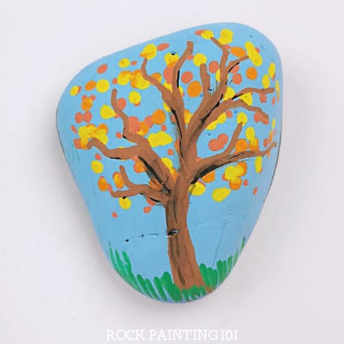 Learn how to use dot painting to make beautiful fall tree painted rocks. This beginner's rock painting idea is perfect for hiding around your neighborhood this fall! #dotpainting #falltree #fallrocks #stonepainting #paintedrocks #howtopainttrees #rockpainting101