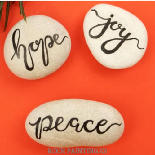 Tips, tutorials, and supplies for mastering hand lettering on painted rocks. Painting fun phrases and inspirational words is a fun way to paint rocks, but it's also one of the most challenging.  #handlettering #rockpainting #howtopaintrocks #kindnessrocks #holidayrocks #paintingwords #rockpainting101
