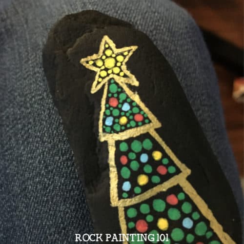 Create this fun dotted Christmas tree rock with this fun video tutorial. This Christmas rock is perfect for beginners and is sure to bring smiles this holiday season! #dotted #christmastree #christmasrocks #paintedrocks #dottedrocks #dotpainting #forbeginners #rockpainting101