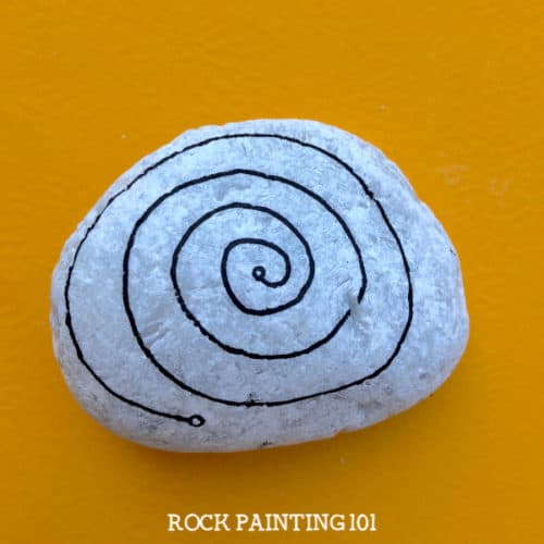 This spiral zendangle rock painting idea is a fun twist on a typical dangle painted rock. Perfect for giving to loved ones or hiding in your city. #spiralzendangle #zendangle #dangles #howtozendangle #rockpaintingideas #love #rockpainting101