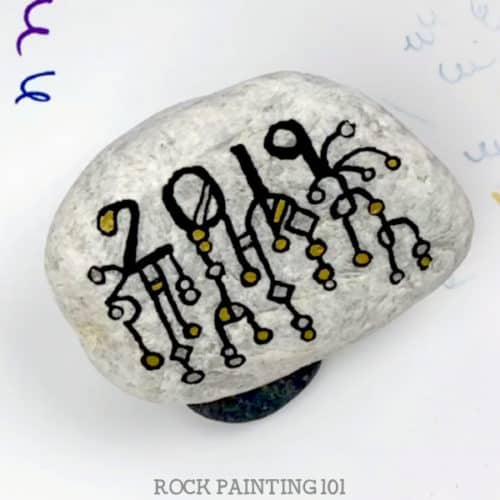 Get ready for New Years with this Zendangle rock painting idea. These are perfect for hiding this season or decorating the table at your New Years Eve party. #newyears #2019 #countdown #zendangle #dangles #rockpainting101