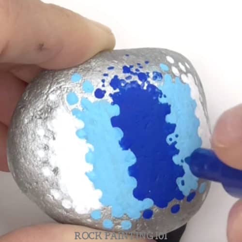 This dot painting backdrop is perfect for painted rocks. Great for adding a holiday message or making a kindness rock. #dotpainting #basecoat #background #backdrop #howtopaintrocks #rockpaintingideas #kindnessrocks #holidayrocks #tutorial #rockpainting101