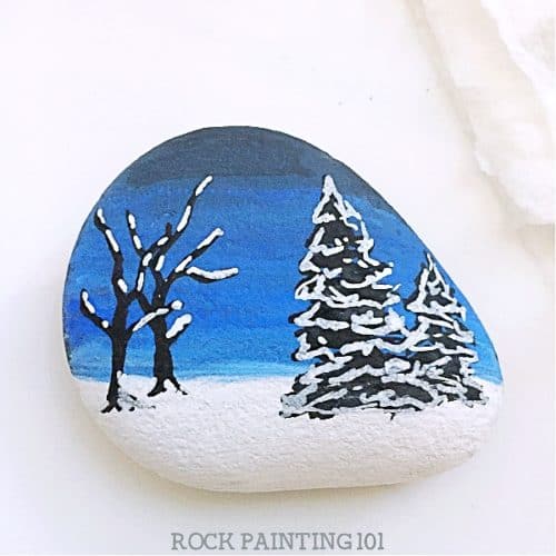 A winter scene rock painting idea is perfect for hiding during these cold winter days. They also make fantastic winter decorations and gift. Practice your blending skills and break out your paint pens, this stone painting tutorial is perfect for all skill levels. #rockpainting101
