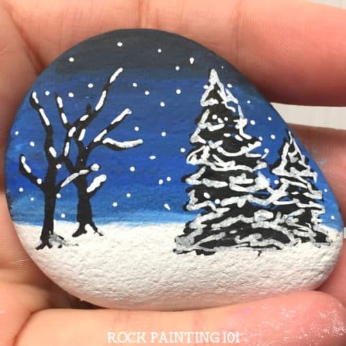 A winter scene rock painting idea is perfect for hiding during these cold winter days. They also make fantastic winter decorations and gift. Practice your blending skills and break out your paint pens, this stone painting tutorial is perfect for all skill levels. #rockpainting101
